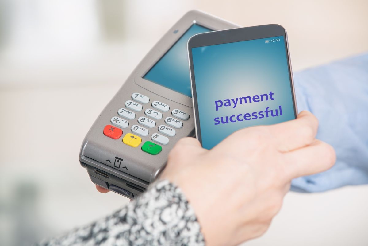 Making contactless payment with smart phone over payment terminal at shop